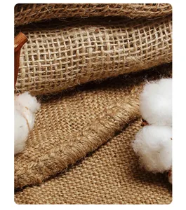 Natural burlap fabric detail shot, rustic texture with cotton bolls for eco home decor.