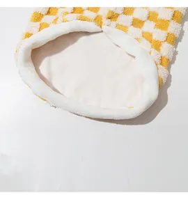 Close-up detail of yellow white checkerboard pet fleece vest interior lining design.