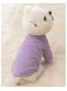 Checkered dog winter clothes detail close-up, warm padded pet apparel showing soft fabric texture.
