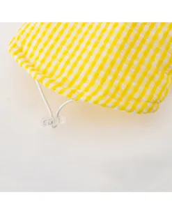 Yellow white checkered pet clothing detail view featuring a secure white drawstring.