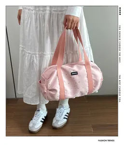 Sac de voyage cylindrique rose pour femme, grand cabas de yoga et bandoulière élégant.