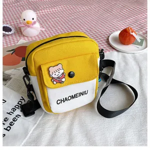 Dettagli della borsa a tracolla in tela gialla e bianca con patch di cartone e tracolla.