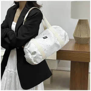 Vue détaillée du sac à épaule cylindrique décontracté pour femmes avec motif d'étoiles.