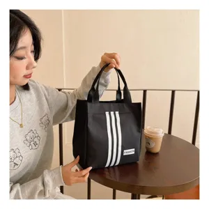 Bolso de almuerzo de lona negra con tres rayas blancas diseño de moda para mujeres y uso diario.