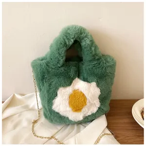 Green plush handbag detail showcasing fluffy texture, fried egg design and gold chain strap.
