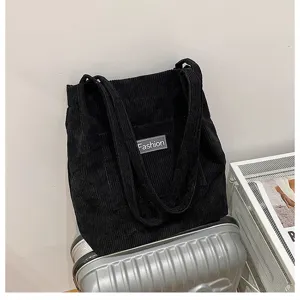 Black corduroy tote bag, retro minimalist single shoulder crossbody casual student bag detail view.