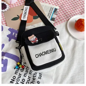 Borsa a tracolla in tela carina per donne, design bicolore bianco e nero con grazioso spilla.