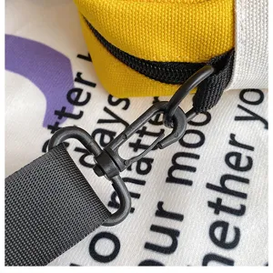 Dettaglio borsa di tela che mostra la fibbia della cinghia nera e la trama dell'hardware.