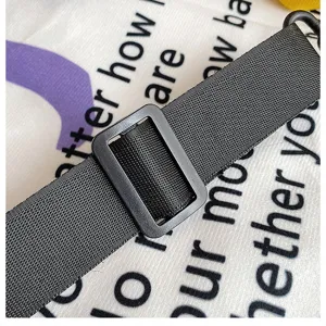 Vista dettagliata della tracolla regolabile in nylon nero con fibbia resistente e rifinita.
