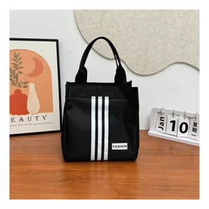 Vista detallada del bolso informal negro elegante con diseño clásico de tres franjas para uso diario.