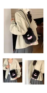 Close-up detail shot of the cute black fluffy crossbody plush bag featuring funny eyes and pink mouth.