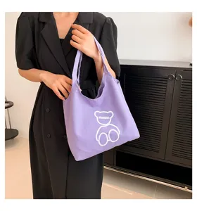 Detailed close-up of a fashionable purple canvas tote bag featuring a cute bear graphic.