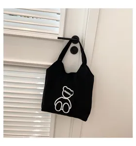Black canvas tote bag featuring a cute white bear embroidery for daily casual use.