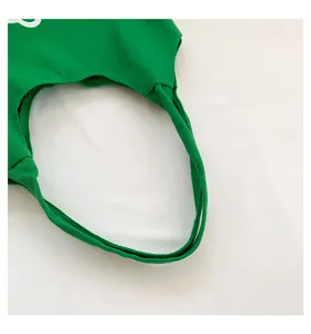 Close up of green canvas tote bag handle, durable cotton fabric with clean stitching detail.