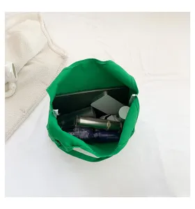 Detailed view of large capacity green canvas tote bag showing interior space and daily items.