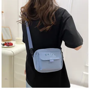 Detail view of the cute solid color nylon crossbody bag, showing strap and front flap pocket.