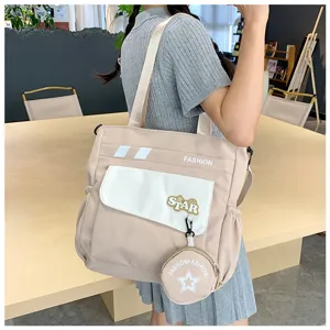 Vue détaillée du sac à bandoulière tendance bicolore avec joli pendentif porte-monnaie rond.