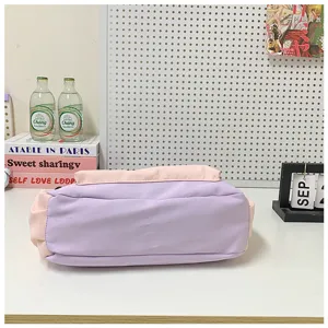 Vue détaillée du sac bandoulière color-block élégant aux tons violet et rose pastel.