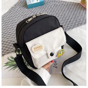 Korean style canvas crossbody bag with contrast color design, cute patches and adjustable strap.
