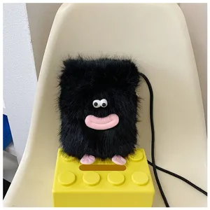 Close up of cute black fluffy plush monster shoulder bag with funny big eyes and pink lips.