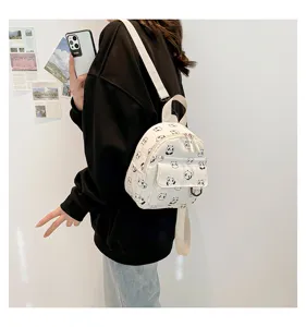 Detail view of the mini canvas backpack showcasing cute panda print and front pocket design.