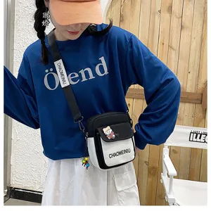 Borsa a tracolla in tela da donna, simpatico design bianco e nero con ciondolo ad orsetto.