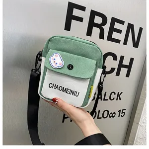 Borsa a tracolla in tela verde e bianca vista di dettaglio, dimensioni compatte con tracolla.