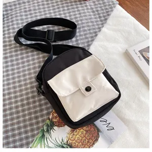 Casual black and white canvas crossbody bag detail, compact phone pouch for daily use.