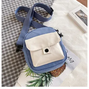 Blue canvas crossbody bag detail showing beige front pocket, adjustable strap and casual design style.