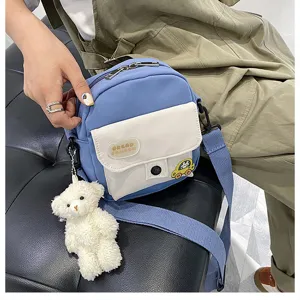 Cute Japanese style canvas crossbody bag with plush bear pendant for daily school use.