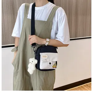 Canvas crossbody bag for women cute black and white shoulder bag with plush bear pendant