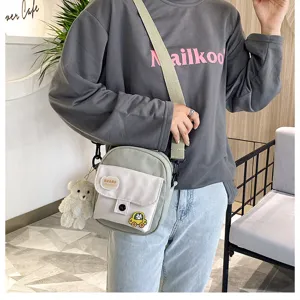 Korean style canvas crossbody bag for women, cute shoulder bag with plush bear pendant and pocket.