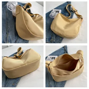 Détail du sac bandoulière en toile avec texture souple et sangle réglable pour un usage quotidien.