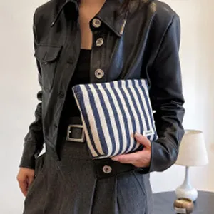 Detail van blauw-witte canvas make-up tas met strepen, draagbare cosmetische opbergtas.