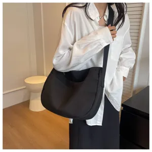 Sac bandoulière décontracté en tissu noir, grand sac souple pour un usage quotidien.