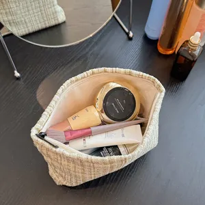 Detailed view of beige tweed cosmetic storage bag, elegant textured zipper pouch showcasing interior capacity.