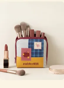 Detailed view of the cute dopamine leather cosmetic storage bag with makeup brushes inside.