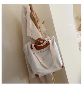 Women's canvas tote bag, versatile single shoulder crossbody handbag with brown leather trim.