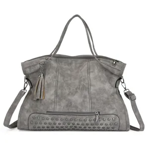 Detailed view of gray PU leather tote bag with metal studs and cute tassel charm.