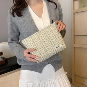 Tweed cosmetic bag detail view, stylish plaid makeup pouch with zipper closure for daily use.