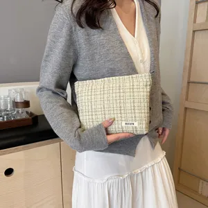 Detailed view of a chic tweed cosmetic bag with elegant texture and zipper closure.