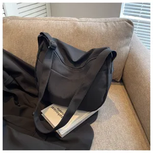Vue détaillée du sac bandoulière en toile noire, matière souple, design décontracté quotidien.