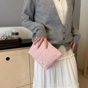 Pink tweed cosmetic pouch detail view, stylish portable makeup storage bag for travel.