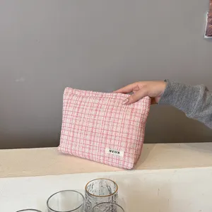 Pink tweed cosmetic bag detail showing soft fabric texture and neat stitching for daily use.
