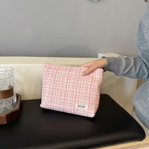 Pink tweed cosmetic pouch detail view, soft fabric texture makeup bag for daily storage.