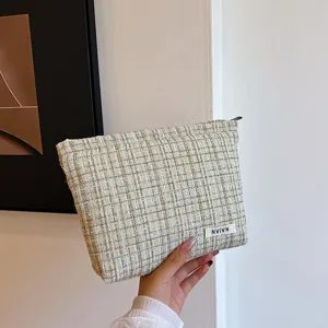 Elegant tweed cosmetic bag for women, chic plaid makeup pouch, portable daily storage bag.