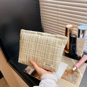Detailed shot of a stylish tweed cosmetic bag with texture, elegant storage pouch for essentials.