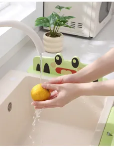 Close-up shot of the green frog kitchen sink splash guard in a clean usage scene.