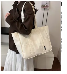Detailed view of large canvas tote shoulder bag, stylish casual commuter bag for daily use.