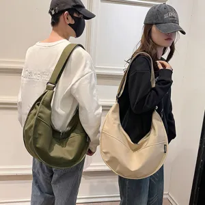 Casual canvas dumpling shoulder bag for women and men, versatile hobo crossbody bag in solid color.